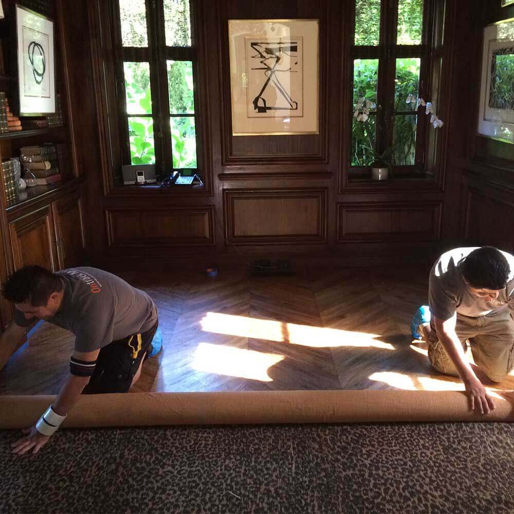 Ontrack Moving crew rolling carpet for home move