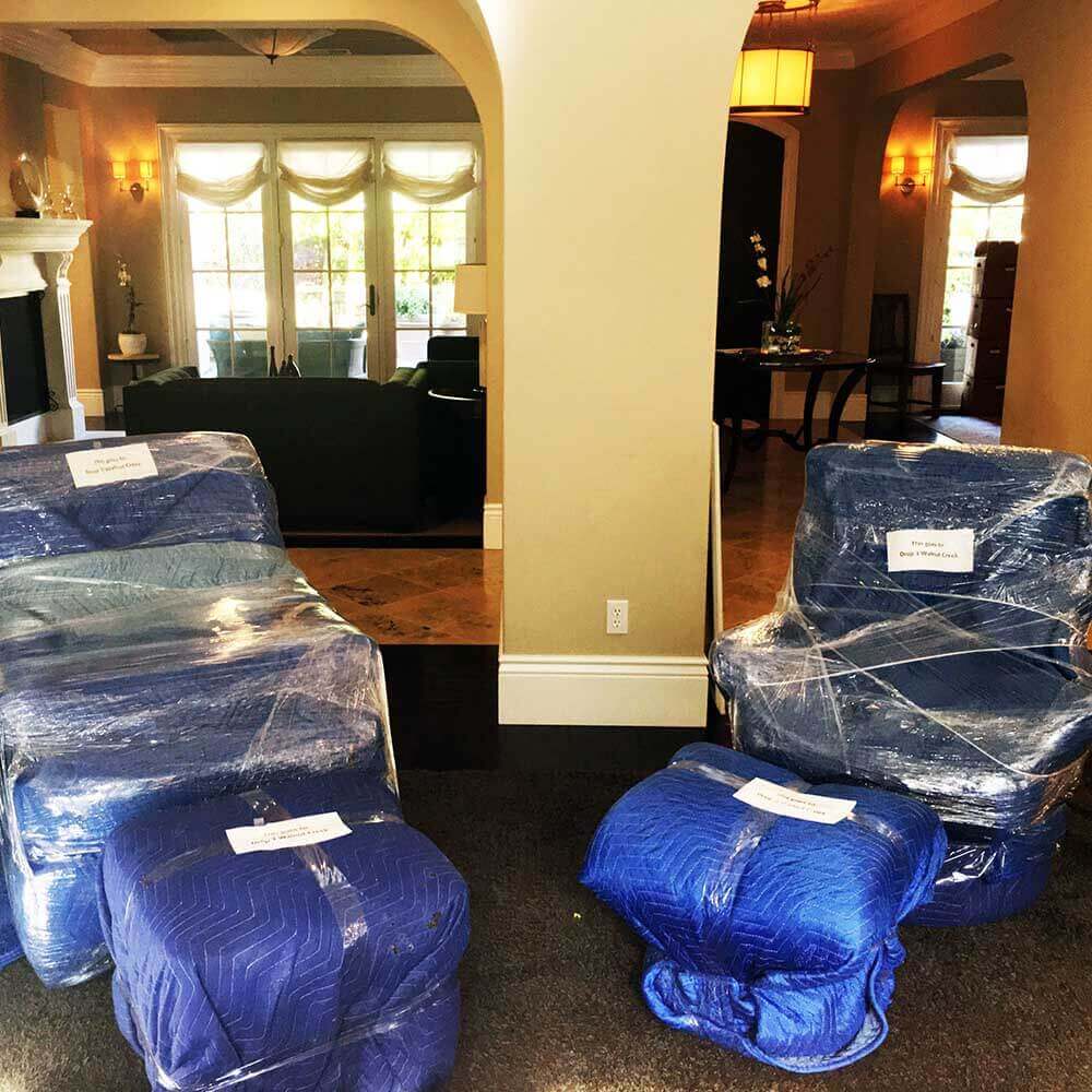 Furniture wrapped in moving blankets and labeled for a Dublin family move